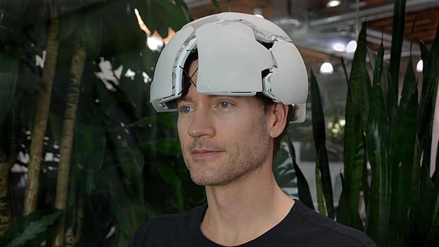 Bryan Johnson wearing a helmet-like device to measure his biomarkers.