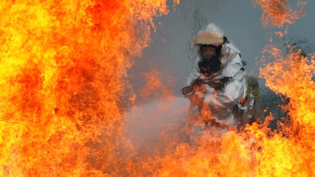A U.S. Air Force firefighter sprays water at the fire of a simulated C-130 Hercules plane crash during operational readiness exercise Beverly Midnight 12-03 at Osan Air Base, Republic of Korea, on July 23, 2012.