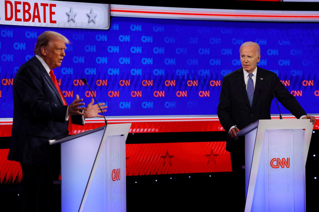 Joe Biden stares at a speaking Donald Trump on stage during a presidential debate.