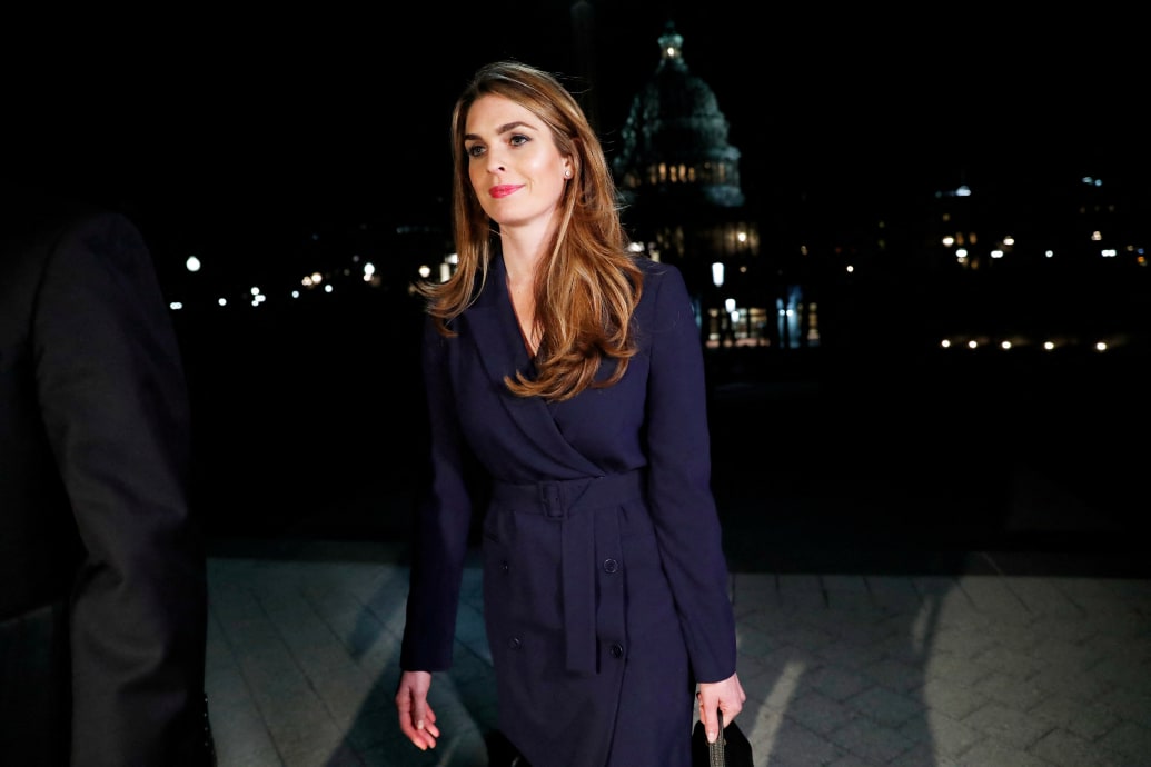 Hope Hicks walks in front of the U.S. Capitol in a blue dress.