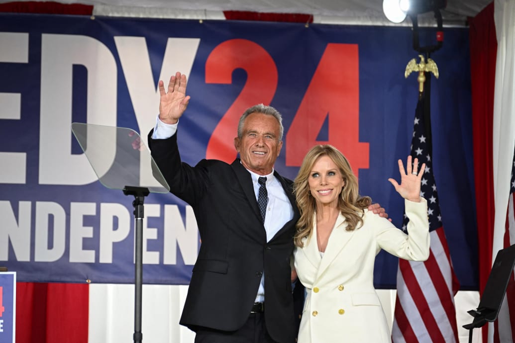 Robert F. Kennedy Jr. and wife, Cheryl Hines, wave together on stage.