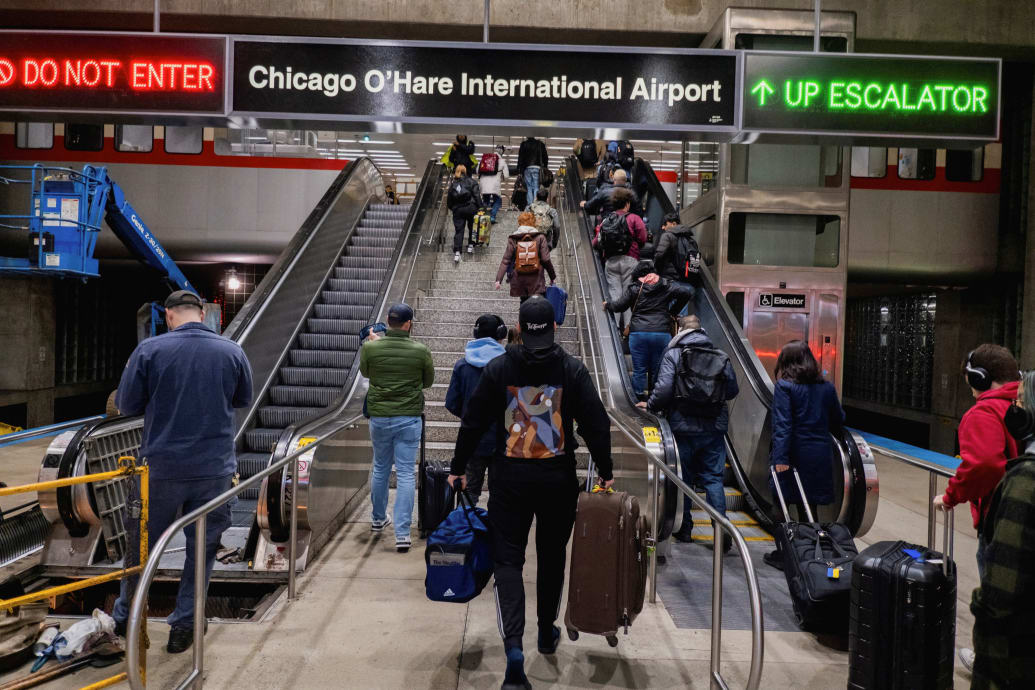 People take an escalator inside Chicago O'Hare International Airport.