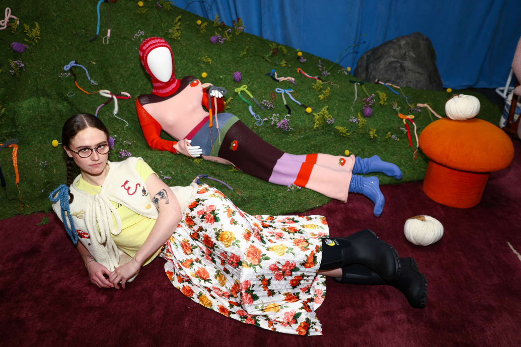 Ella Emhoff poses during New York Fashion Week by lying on the ground in an artsy dress.