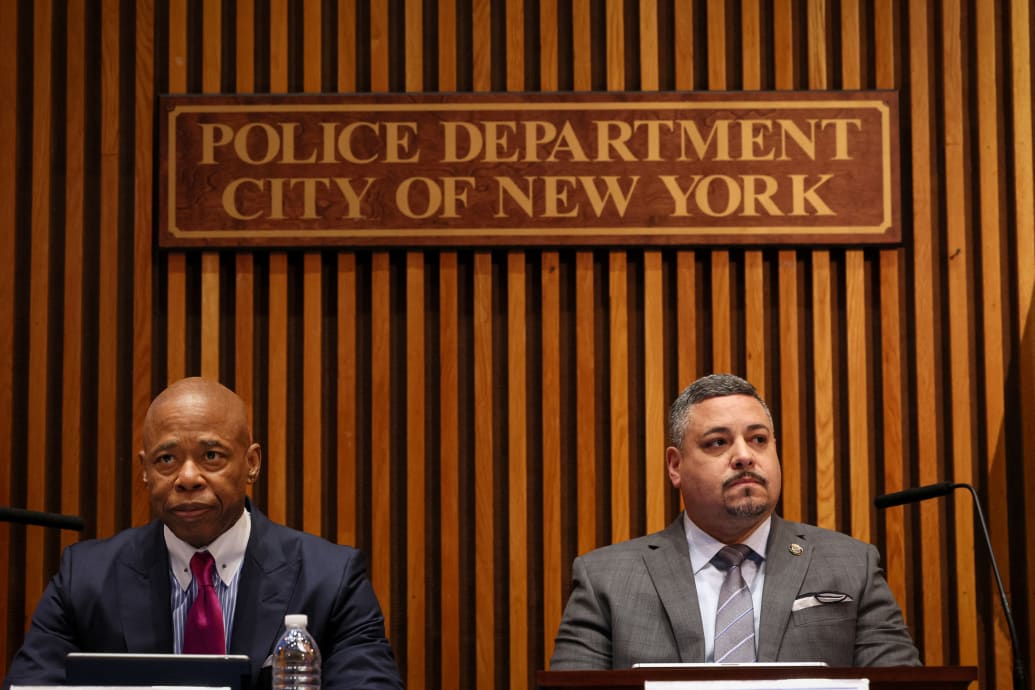 Mayor Eric Adams and Commissioner Edward Caban stare forward during a press conference.