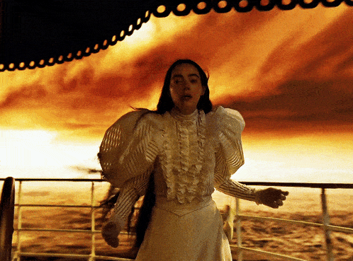 gif shows Emma Stone's character walking in a white formal blouse and blood coming from her nose.