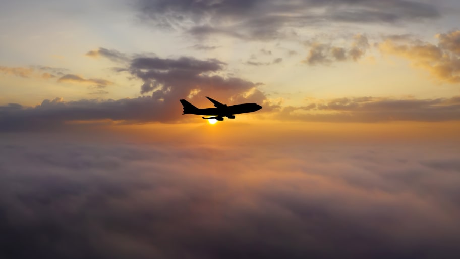 Airplane at sunset above the clouds.