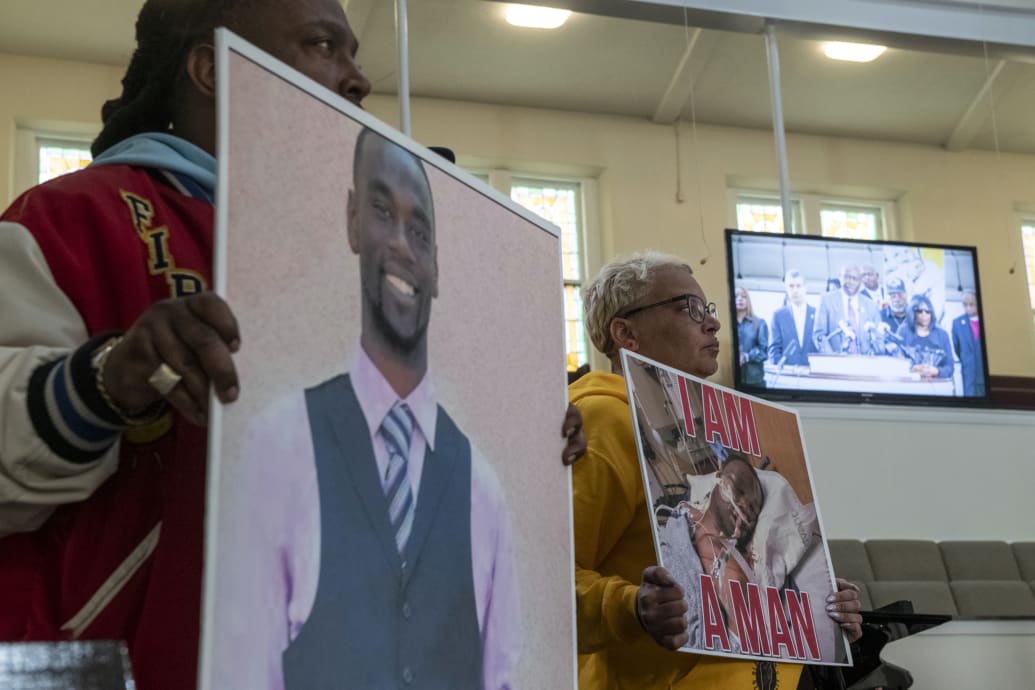 Activists hold signs showing Tyre Nichols during a press conference.