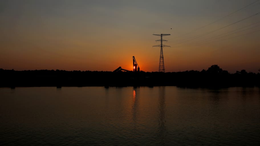 The sun sets behind grain elevators at the Bunge Grain facility along the Ohio River in Owensboro, Kentucky. 
