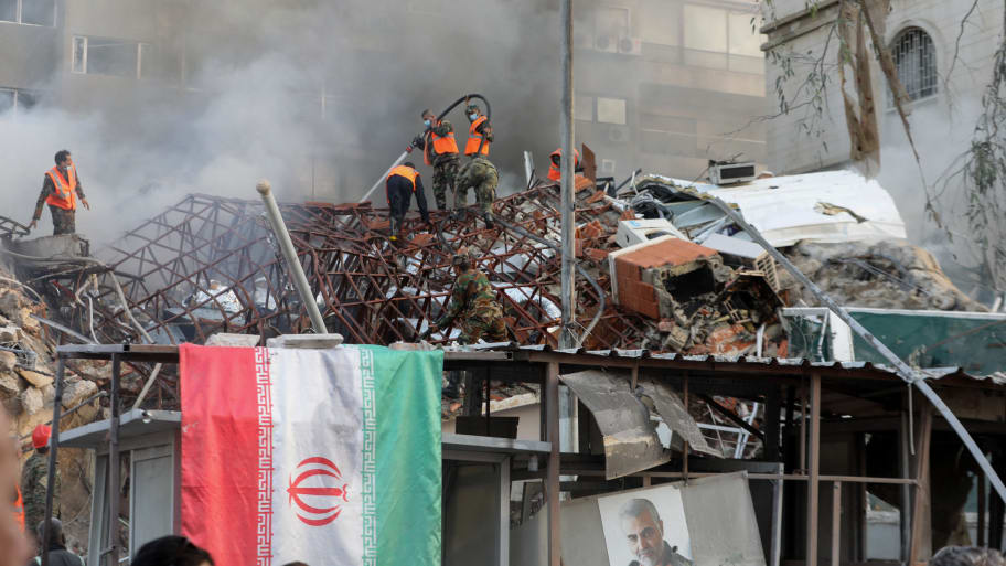 Emergency and security personnel extinguish a fire at the site of strikes which hit a building annexed to the Iranian embassy in Syria's capital Damascus, on April 1, 2024.