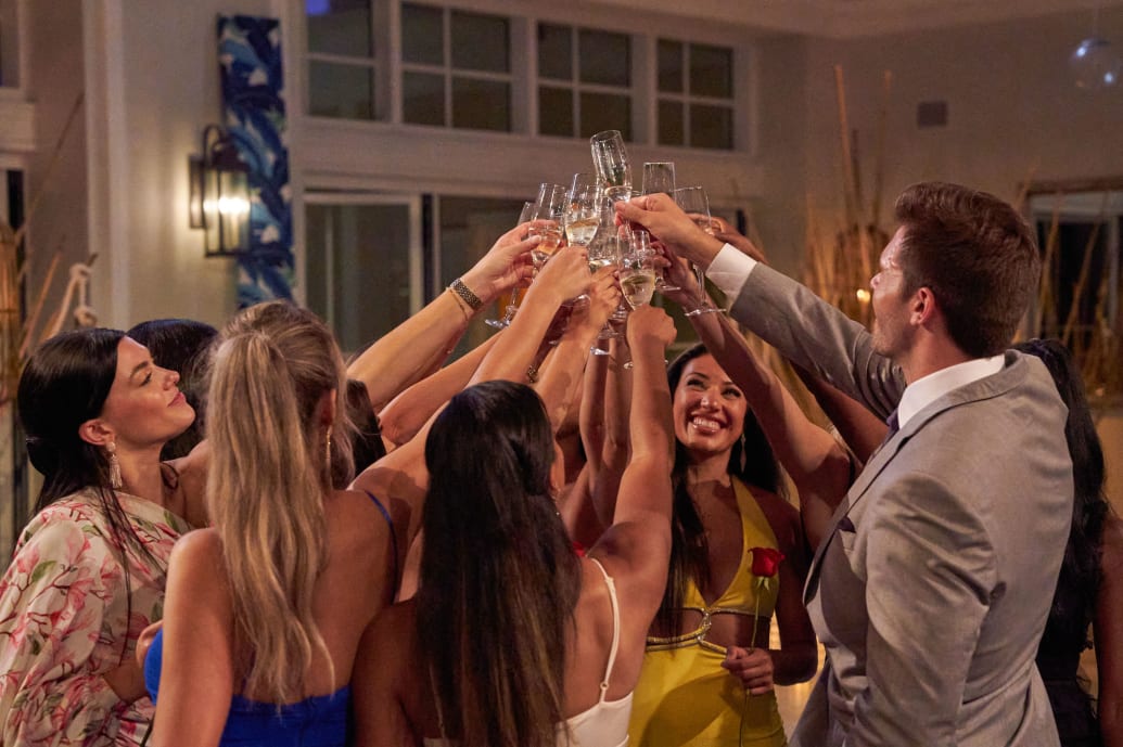 Zach and the women do a champagne toast after a rose ceremony.