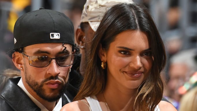 Bad Bunny and Kendall Jenner walk courtside at an NBA game.