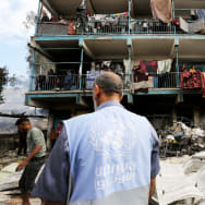 An UNRWA employee looks on at Palestinians in a school attacked by Israeli forces in Gaza on May 14, 2024.