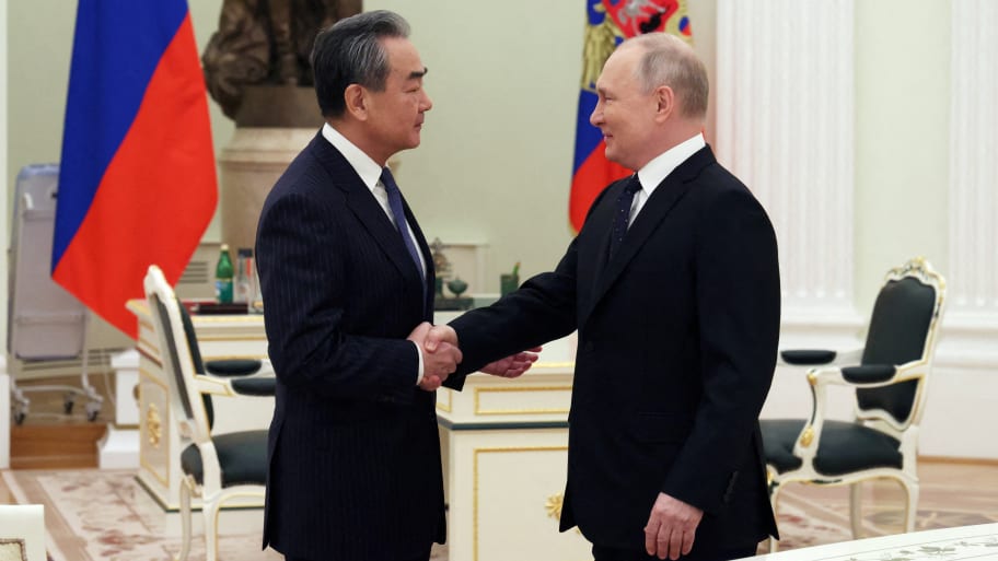 Russia's President Vladimir Putin shakes hands with China's Director of the Office of the Central Foreign Affairs Commission Wang Yi during a meeting in Moscow, Russia February 22, 2023. 