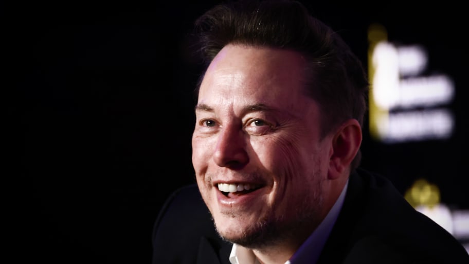 Elon Musk smiling on a stage.