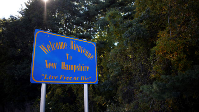 A welcome sign at the New Hampshire border that says “Live Free or Die.”