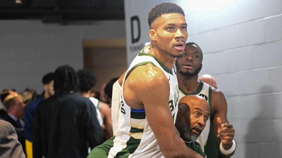 Giannis Antetokounmpo is restrained as he tries to reach Indiana Pacers players postgame.