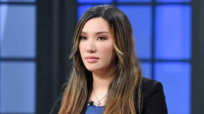 Lauren Chen stares forward on a TV set.