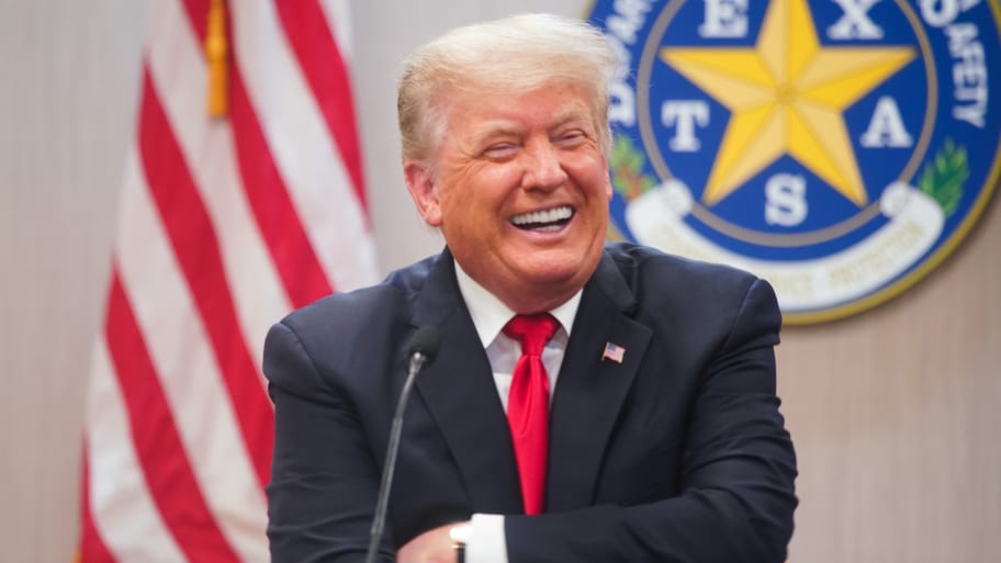 Former U.S. President Donald Trump laughs as he attends a border security briefing with Texas Governor Greg Abbott