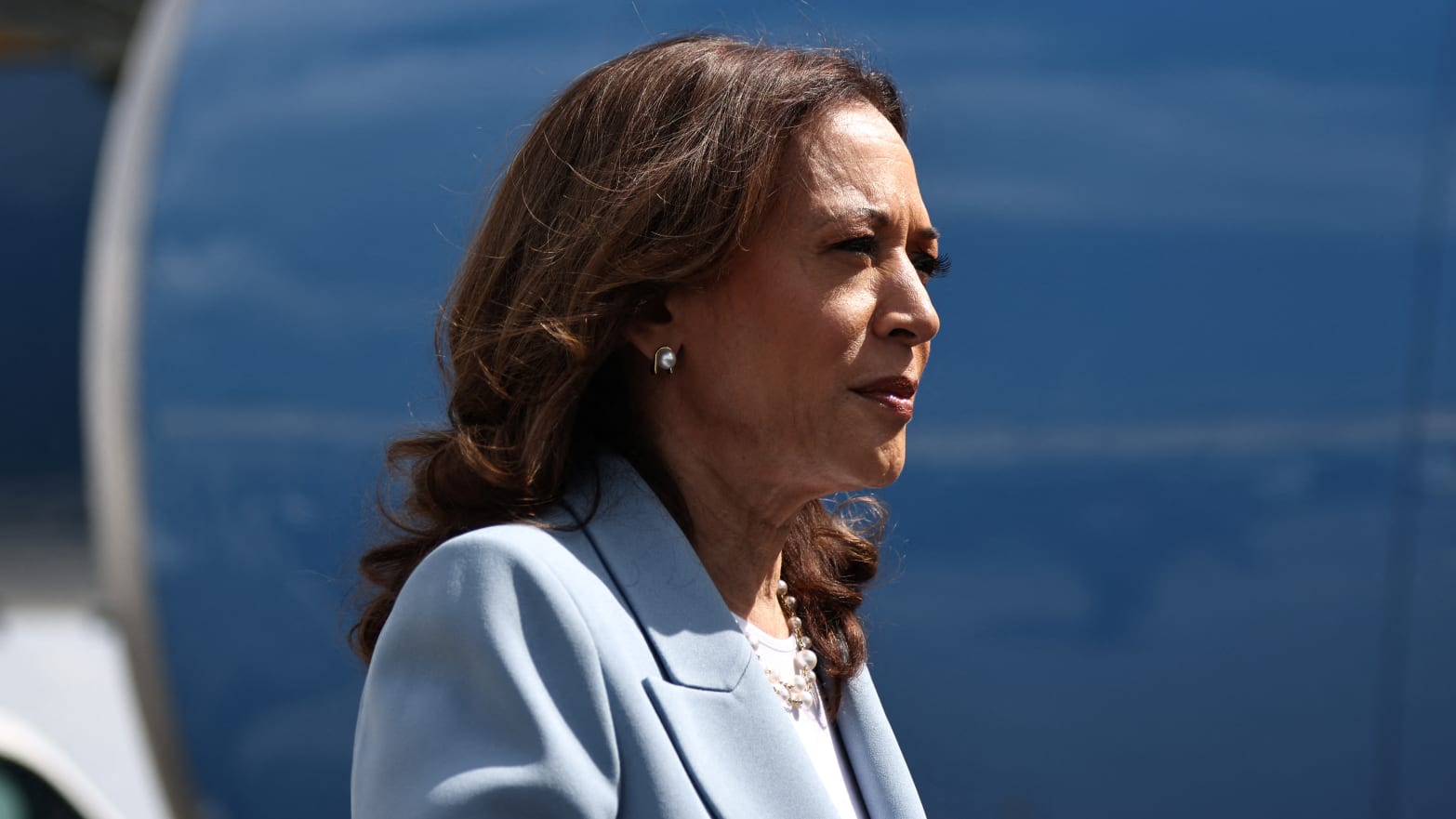 Kamala Harris stares forward while walking on a tarmac.