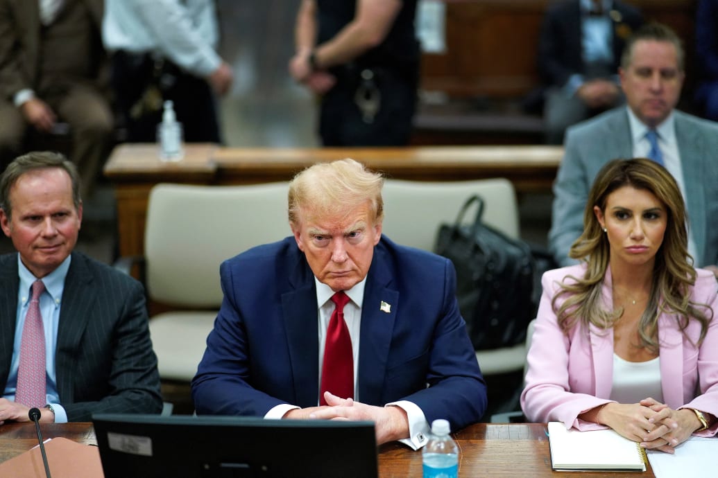 Former President Donald Trump sits at the defense table with his attorney’s Christopher Kise and Alina Habba