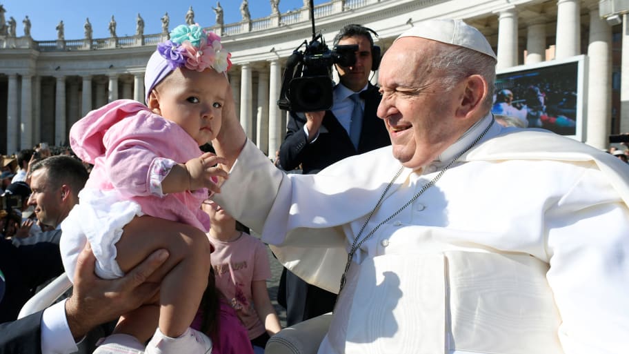Pope Francis greets a child as he holds the weekly general audience in St. Peter’s Square at the Vatican, June 7, 2023. 