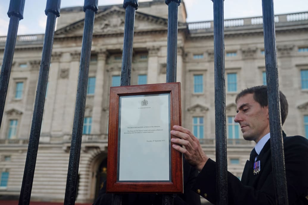 A member of the royal household staff places a notice of Queen Elizabeth II’s death outside Buckingham Palace.