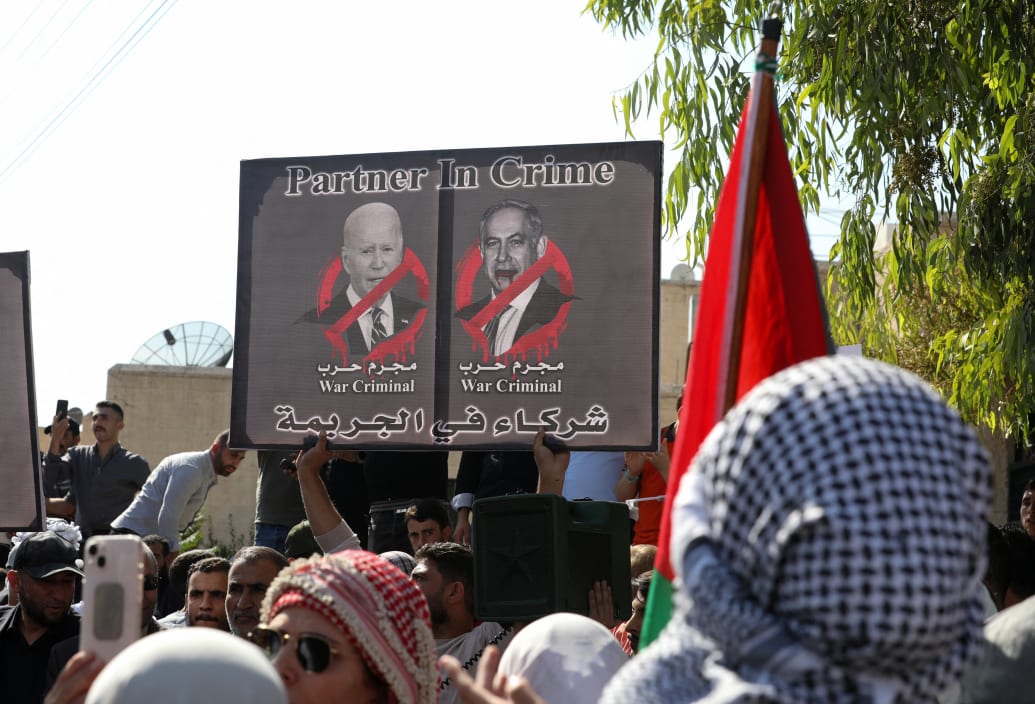 A poster labels President Joe Biden and Israeli Prime Minister Benjamin Netanyahu as “war criminals” it a protest in Amman, Jordan.