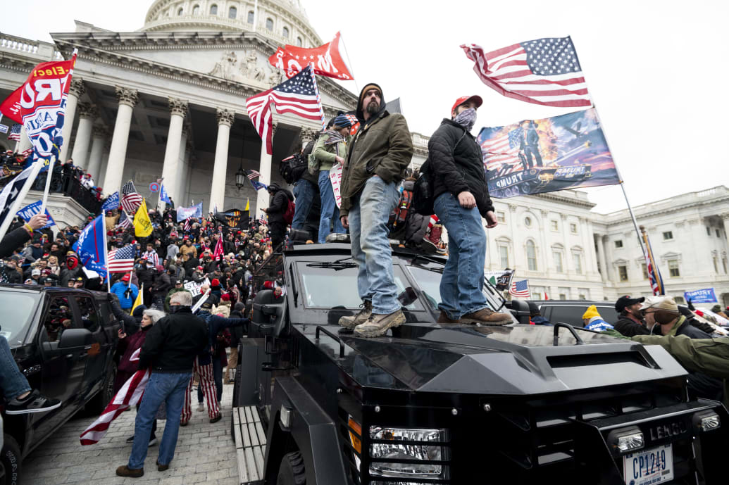Trump supporters stand on a U.S. Capitol Police armored vehicle on Jan. 6, 2021.