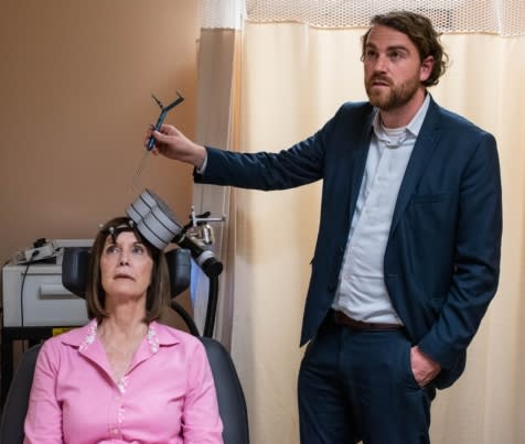 Nolan Williams demonstrates SAINT, the magnetic brain stimulation therapy he and his colleagues developed, on Deirdre Lehman, a participant in a previous study of the treatment.