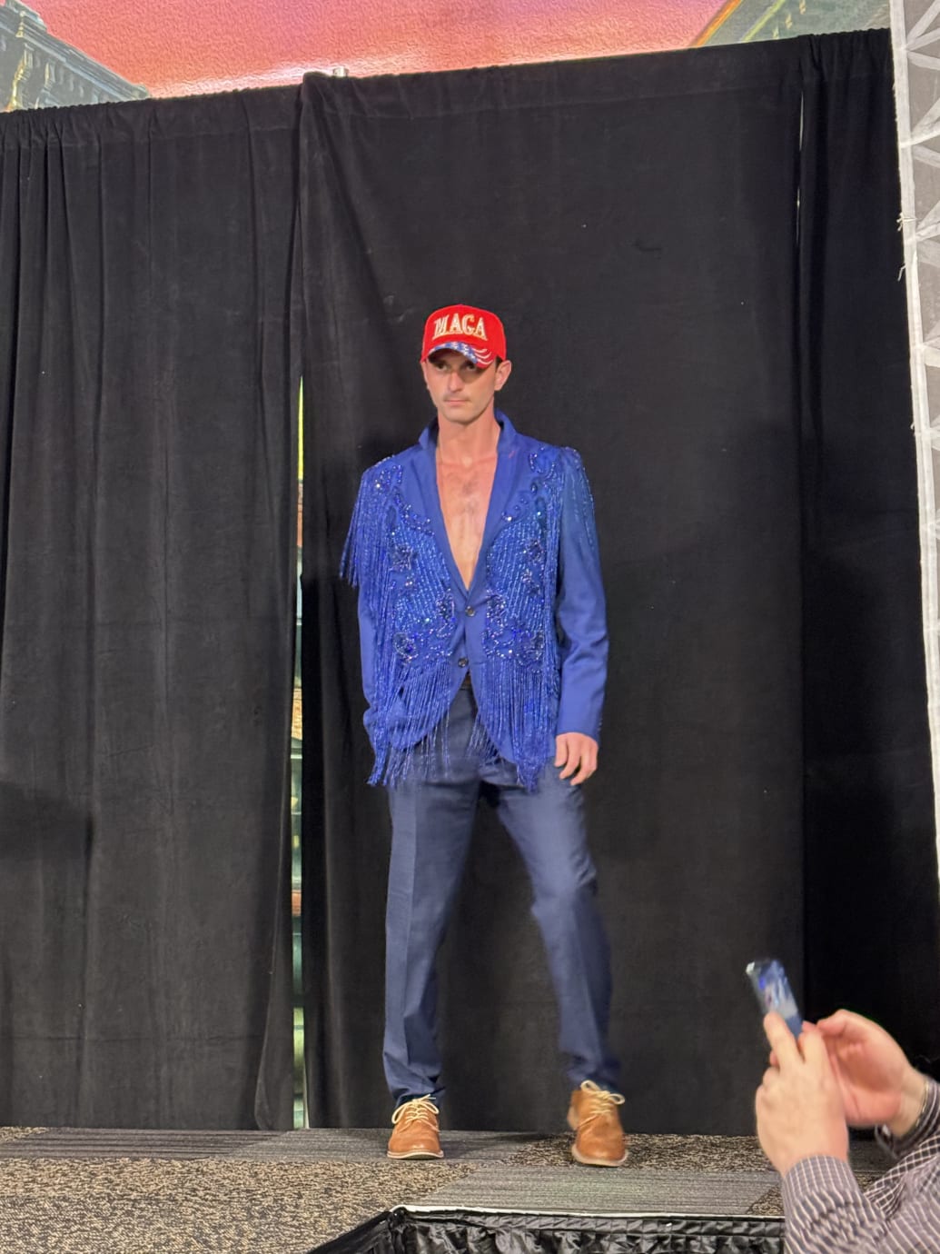 A male model on the runway in a bold blue dinner jacket—and jeans.