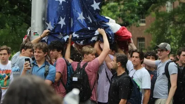 Members of the Pi Kappa Phi fraternity at UNC-Chapel Hill raise the US flag during a pro-Palestinian protest on campus.