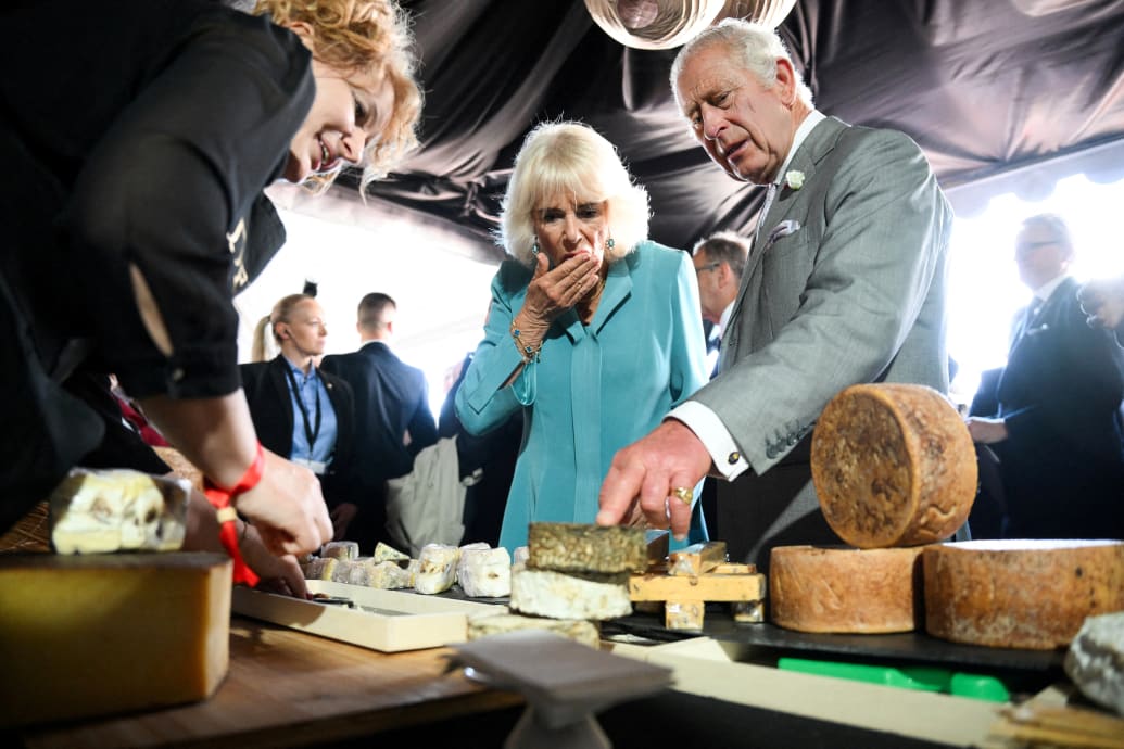 Britain's King Charles and his wife Queen Camilla sample some cheese during a visit to a festival in celebration of British and French culture and business at Place de la Bourse in Bordeaux, southwestern France, on September 22, 2023