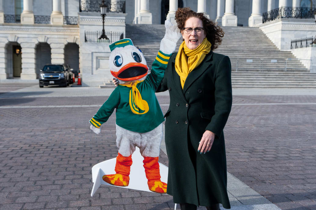 Rep. Val Hoyle (D-OR) poses for photos with a cutout of the University of Oregon Duck mascot outside the Capitol.