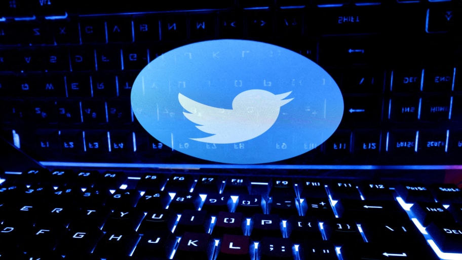 A keyboard is placed in front of a displayed Twitter logo in this illustration.