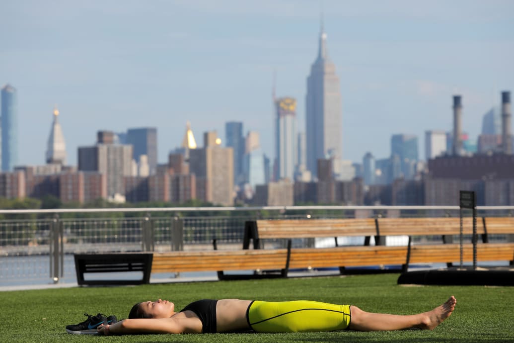 A woman lies in Domino Park as a heatwave continues to affect the region in Brooklyn, New York, U.S., July 21, 2019.