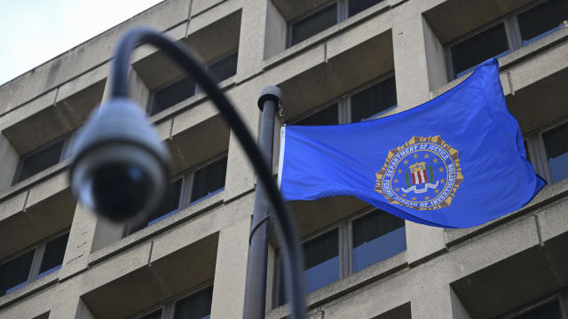 A photo of FBI headquarters and a bureau flag flying out front.
