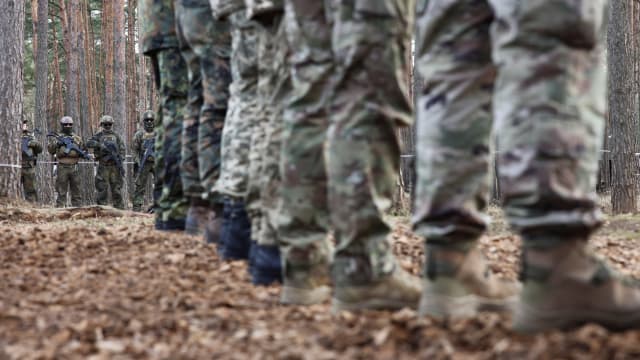 Dozens of soldiers stand at attention during a training exercise.