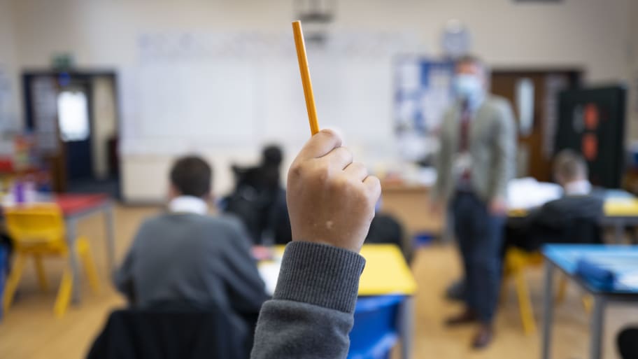 A pupil raises their hand during a lesson at Whitchurch High School.