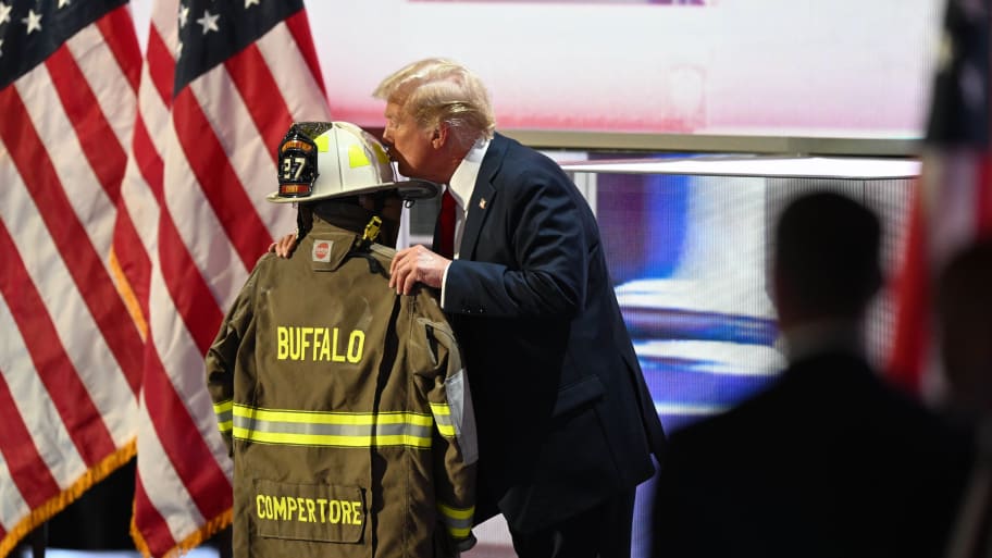  Former president Donald Trump kisses the fire gear belonging to Corey Comperatore on the final night of the Republican National Convention at Fiserv Forum on July 18, 2024 in Milwaukee, Wisconsin.