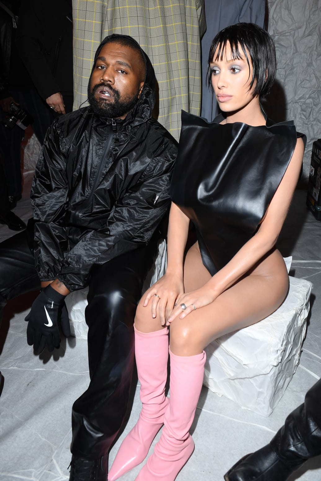 Kaney West and Bianca Censori sit at a fashion week show. 