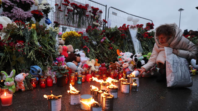 People light candles in honor to the victims of the Crocus City Hall terrorist attack near the Crocus City Expo Complex on March 23, 2024 in Krasnororsk, Russia.