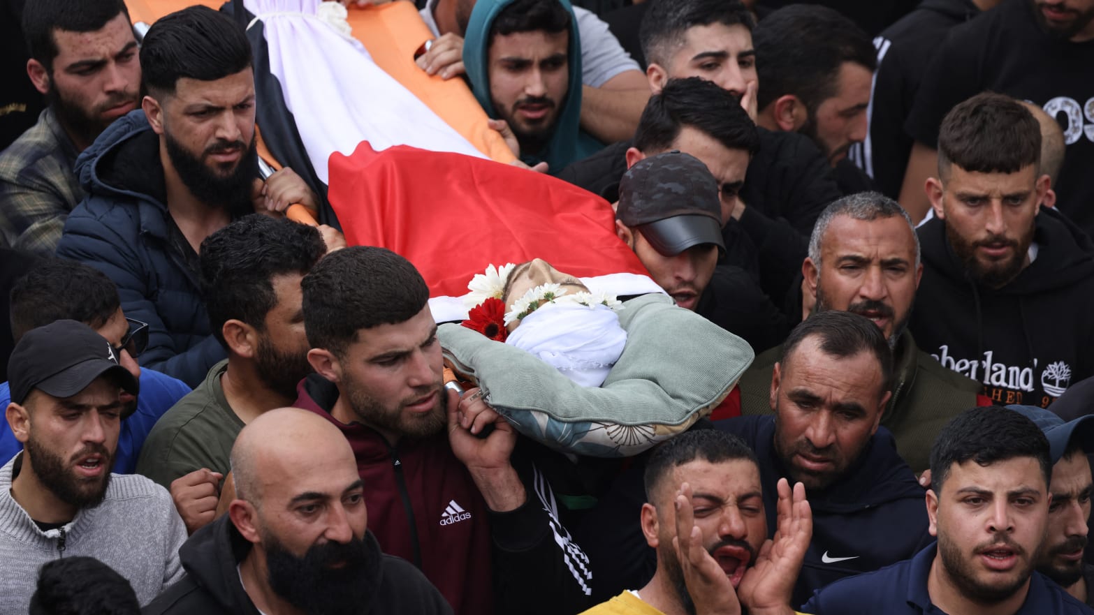 Mourners carry the body of Jihad Abu Alia, who was killed in clashes with Israeli settlers in the village of Mughayir, on April 13, 2024. 