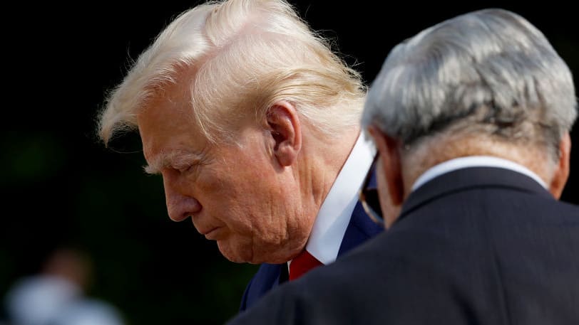 Donald Trump looks down while walking at Arlington National Cemetery.