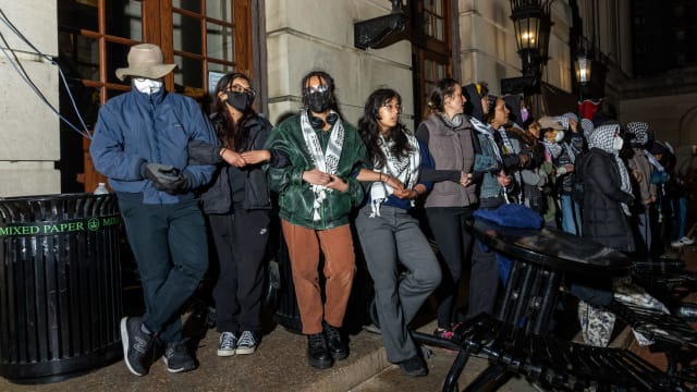 Demonstrators link arms to protect their fellow protestors barricaded inside Hamilton Hall from authorities as members of the NYPD surround the Columbia University campus to clear the pro-Palestinian protest encampment on April 30, 2024 in New York City.