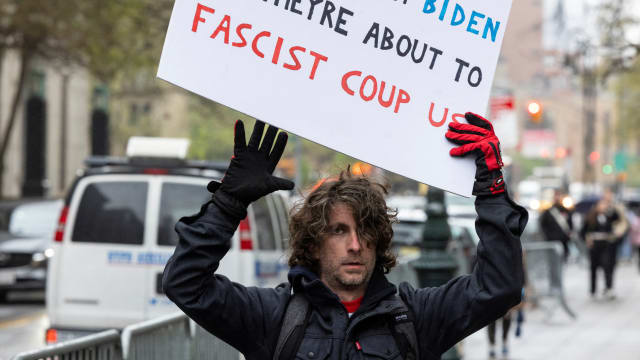 Maxwell Azzarello holds a sign that warns of a “fascist coup.”