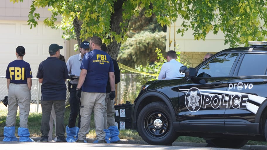 FBI officials and other law enforcement officers stand outside the home of Craig Robertson who was shot and killed by the FBI in a raid on his home on August 9, 2023 in Provo, Utah.