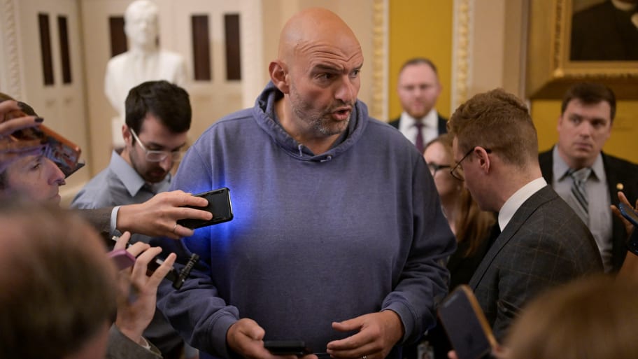 John Fetterman, wearing a blue hoodie on Capitol Hill, speaks with reporters.