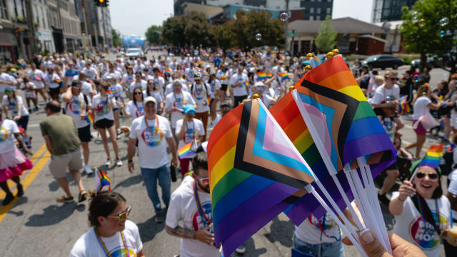 Parade participants holding Pride flags are seen during the Kentuckiana Pride Parade.