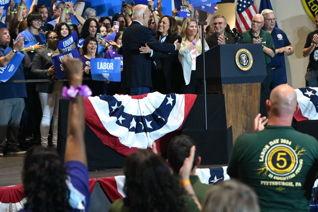 US President Joe Biden (C-L) embraces US Vice President and Democratic presidential candidate Kamala Harris during a campaign rally at the International Brotherhood of Electrical Workers (IBEW) Local 5 in Pittsburgh.