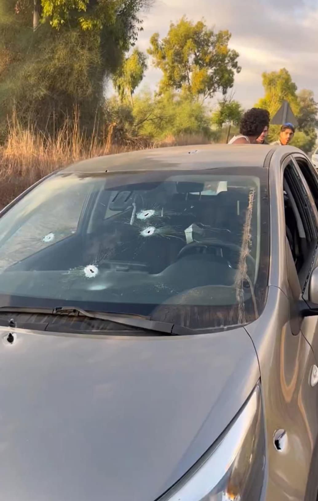 Ofir Nimni, Ido and Yovel near their bullet-strewn car
